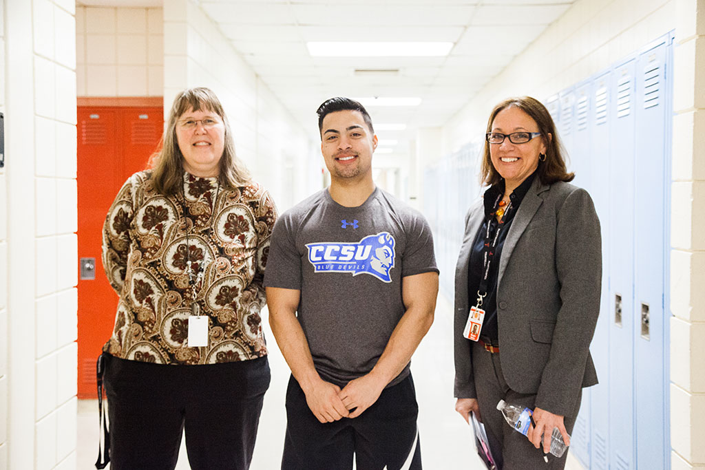 10:45 a.m. — Teacher Wendy Fusco, pictured on the left, nominated a student, Connor Monahan, for a “Tiger Shout Out” for saving a life while lifeguarding at a local YMCA. Baker helps in recognizing Monahan. (Photo credit: Cat Boyce/Neag School)