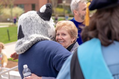 Mary Anne Doyle hugs UConn Husky Dog mascot during Commencement weekend.