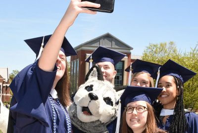 Grad students take a selfie with Jonathan the Husky mascot at the Neag School’s Commencement reception for master’s and sixth-year students.