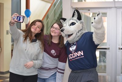 Students take a selfie with Jonathan the Husky at the Gentry Building during UConn’s Giving Day in March. (Shawn Kornegay/Neag School)