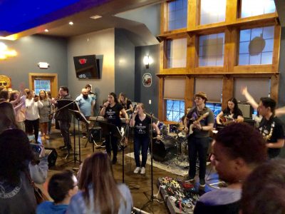 Faculty, staff, and students from the Department of Curriculum and Instruction perform at the Knot Restaurant earlier this month.