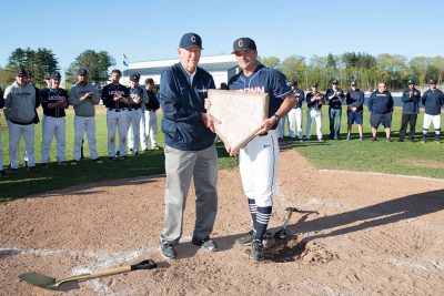 Baseball's Jim Penders ’94 (CLAS), ’98 MS,, right, accepts the home plate from Andy Baylock. (Stephen Slade/UConn Today)
