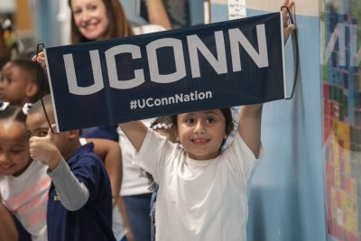 Little girl holds up UConn sign.