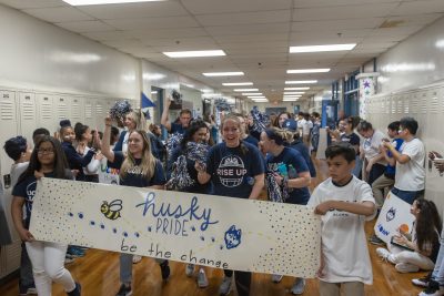 Schoolchildren, teachers, and Neag School of Education student interns parade through the halls of Kennelly School in Hartford to celebrate UConn Day.