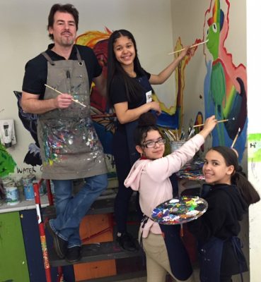 Jason Gilmore painting with his students.