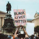 Man at Philadelphia protest holds Black Lives Matter poster.