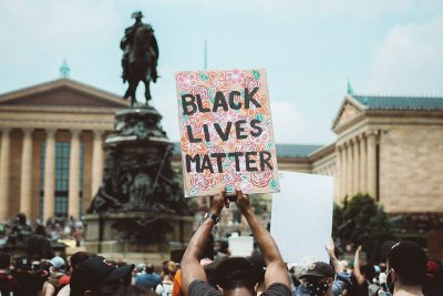 Man at Philadelphia protest holds Black Lives Matter poster.