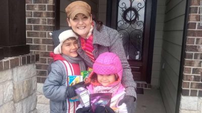 Neag School alum Karen Rambo-Hernandez and her two children gather on doorstep.