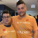 Daniel Crovo, Class of 2021 Neag School senior (right), stands with his brother. Both are smiling and wearing orange t-shirts.