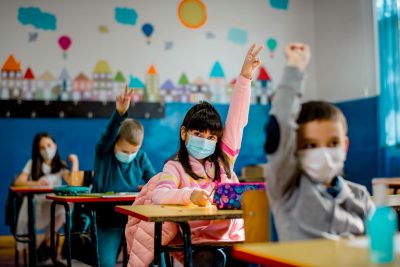 Kids wearing masks in classroom. Sandra Chafouleas says 'behavioral vaccines' can help support students' well-being.