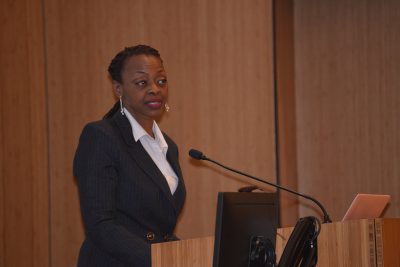 Black female wearing suit gives a speech.