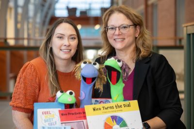 Feel Your Best Self founders Emily Wicks, left, and Sandra Chafouleas, right, pose with some of the sock puppets, books and kits that are part of the program in Gentry Building.