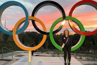 Female professional stands in front of Olympic rings.