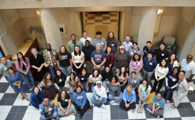 Group of students and faculty gather in the Neag School atrium.