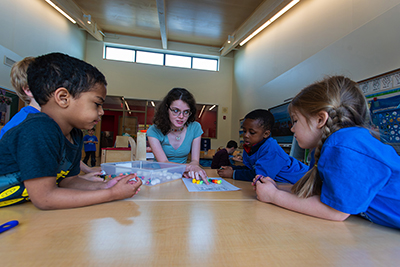 Female educator works with students in a class. 