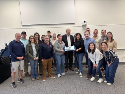 A group of adults stand together in a classroom.