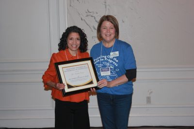 Tutita Casa receives an award from another woman.